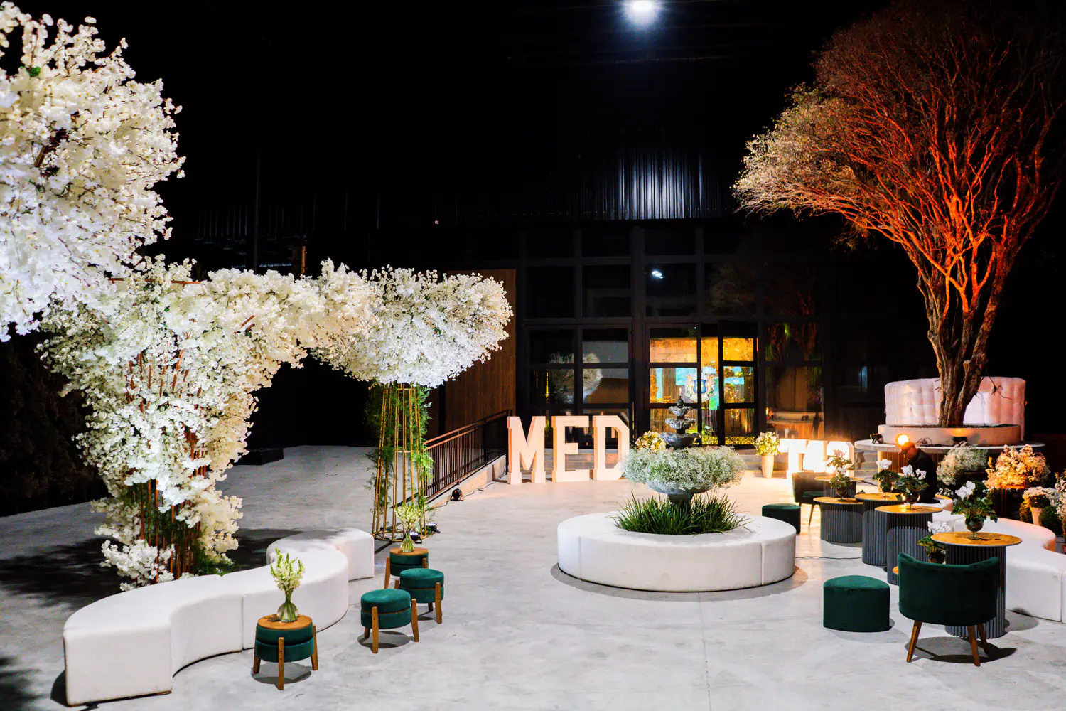 Ambiente de recepção de formatura com mobiliário claro e flores.