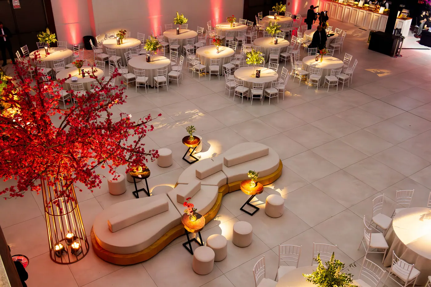 Mesas de formatura decoradas com arranjos florais e iluminação cênica.