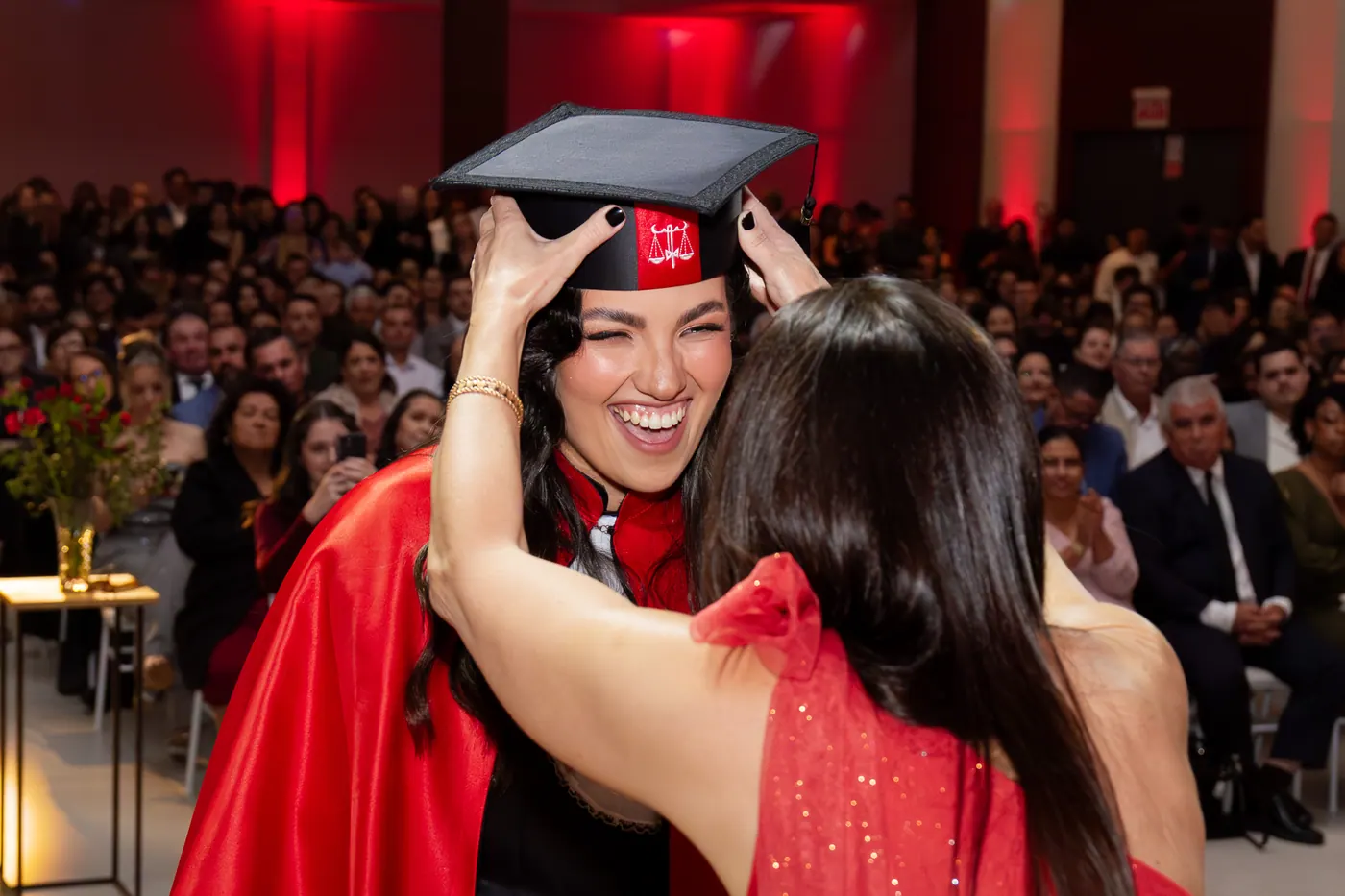 Formanda recebendo o capelo durante a cerimônia de formatura.